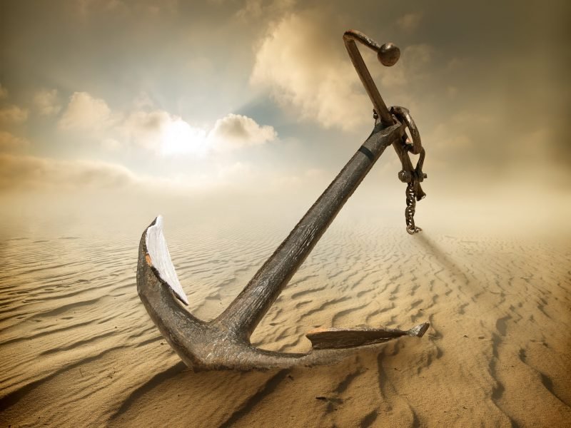 Anchor in the desert and cloudy sky